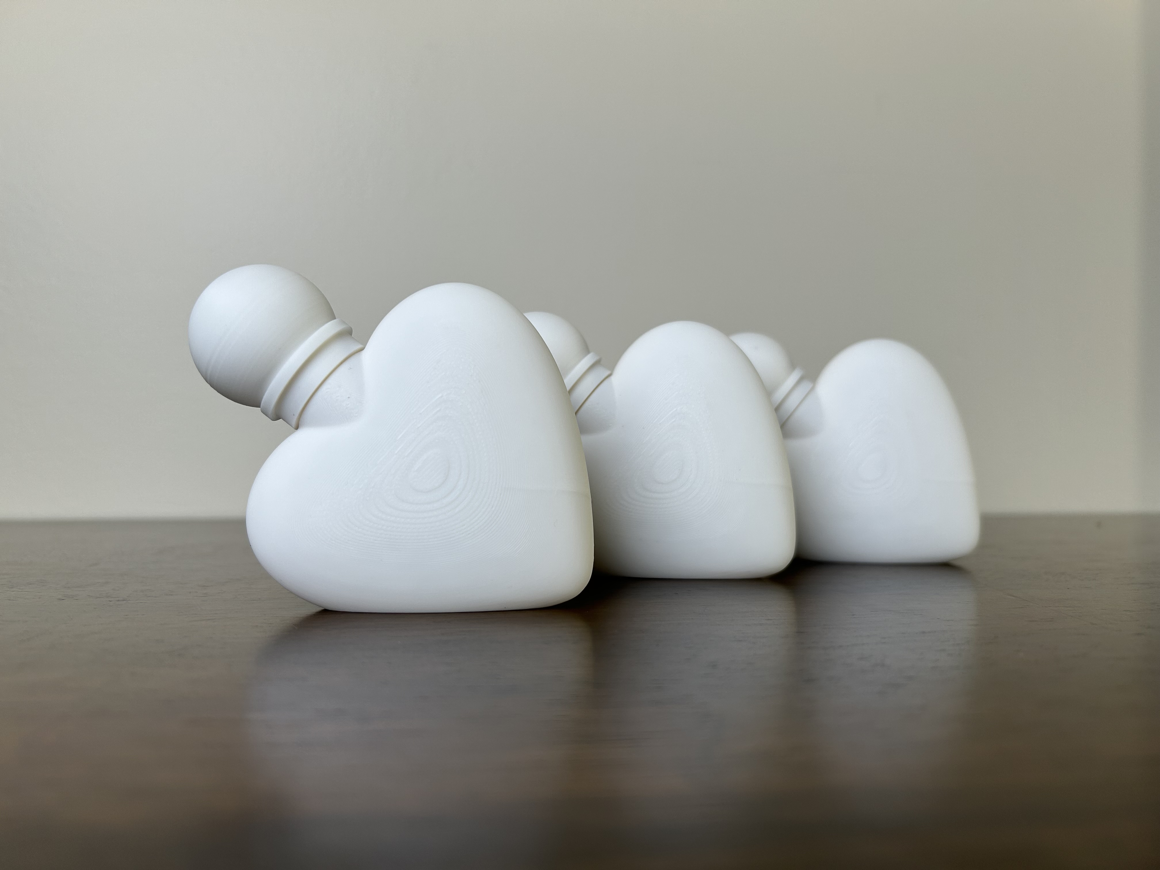 Three FDM-printed and assembled perfume bottles in matte black, grey and cream